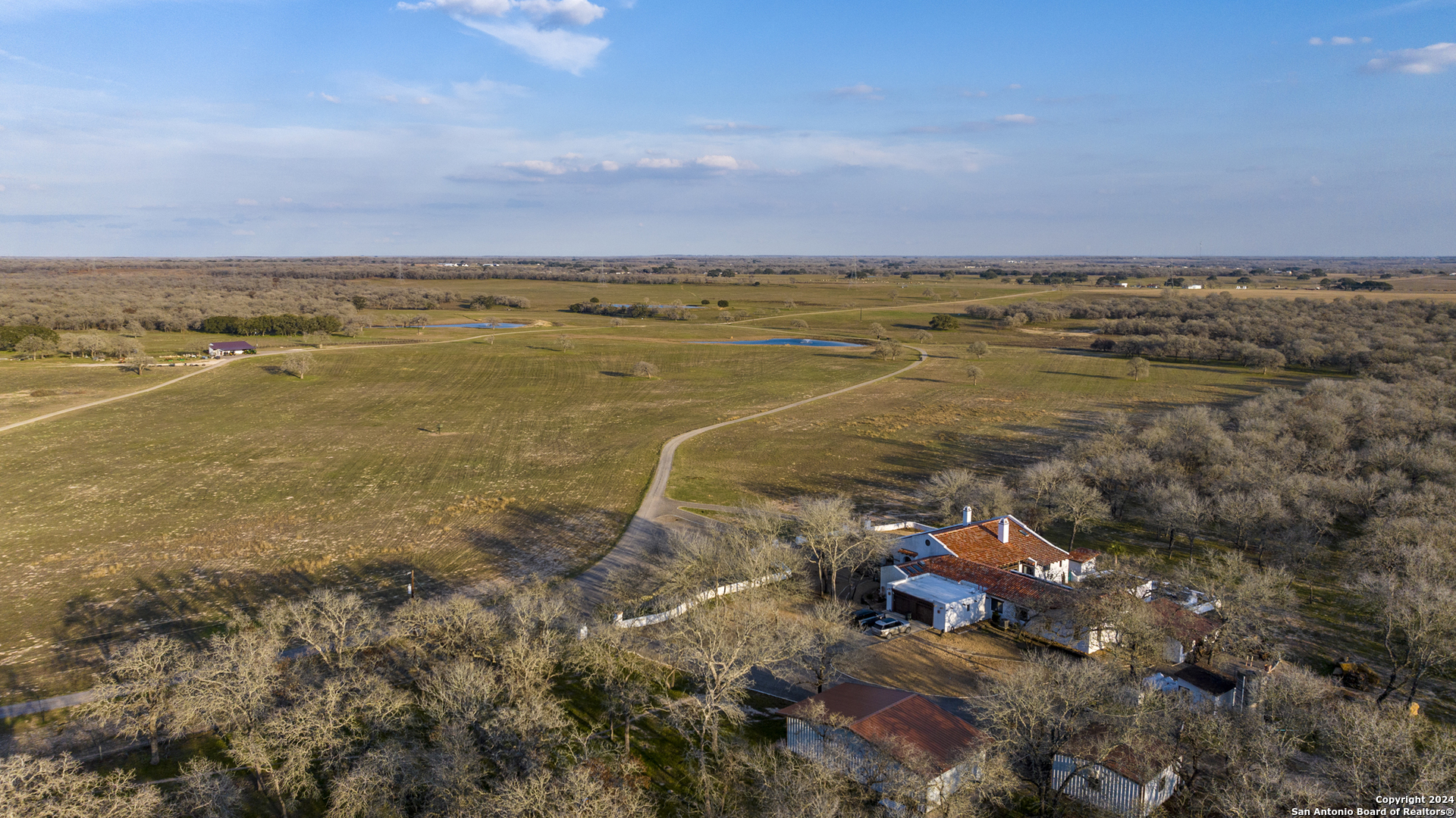 an aerial view of ocean and residential houses with outdoor space