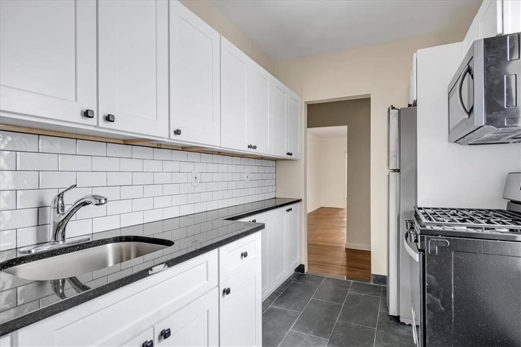 a kitchen with stainless steel appliances a sink a stove and cabinets