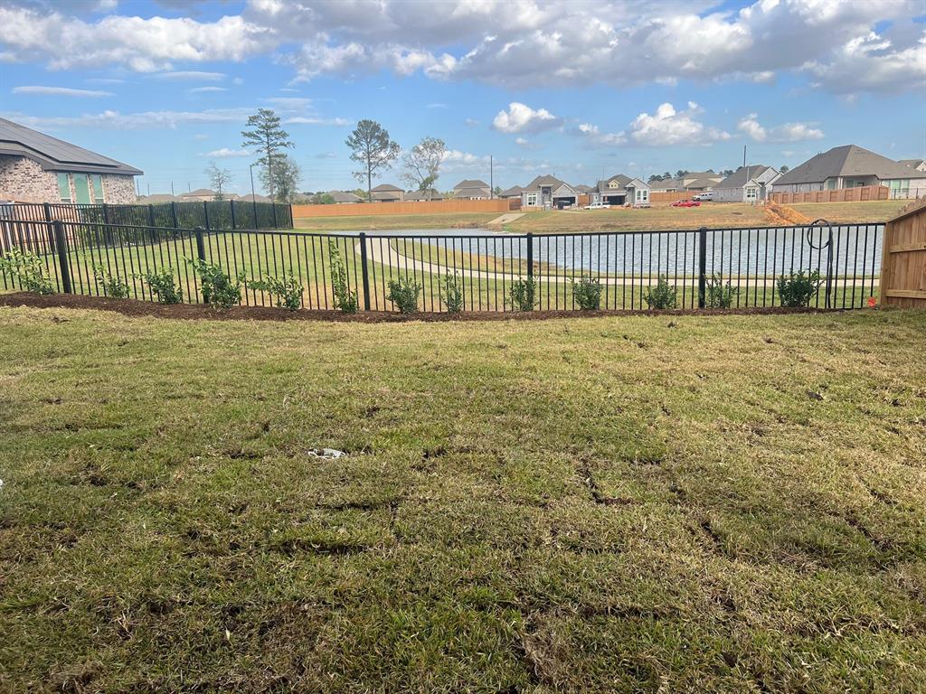 a view of a garden with a wrought fence