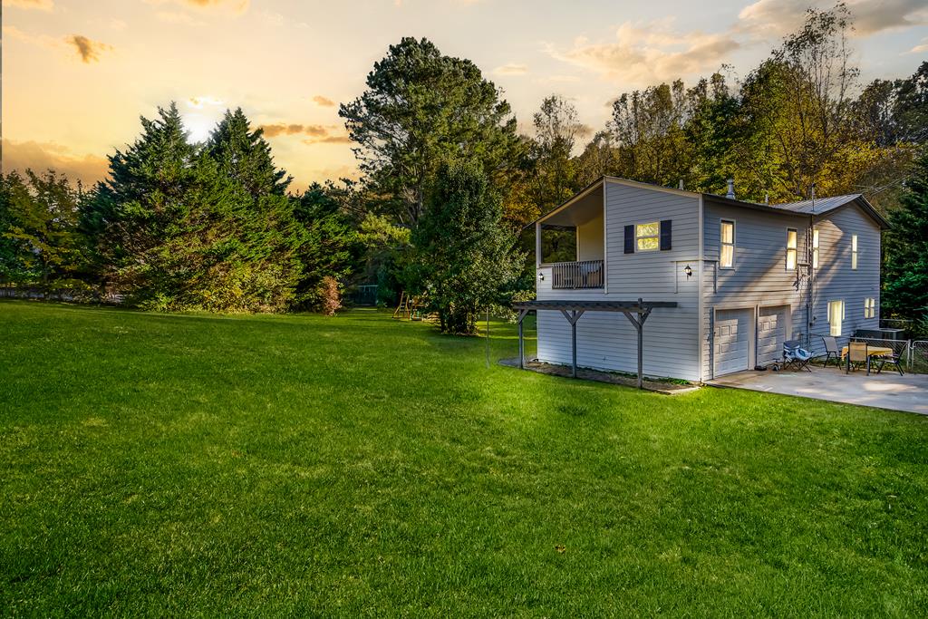 a front view of a house with a yard and trees