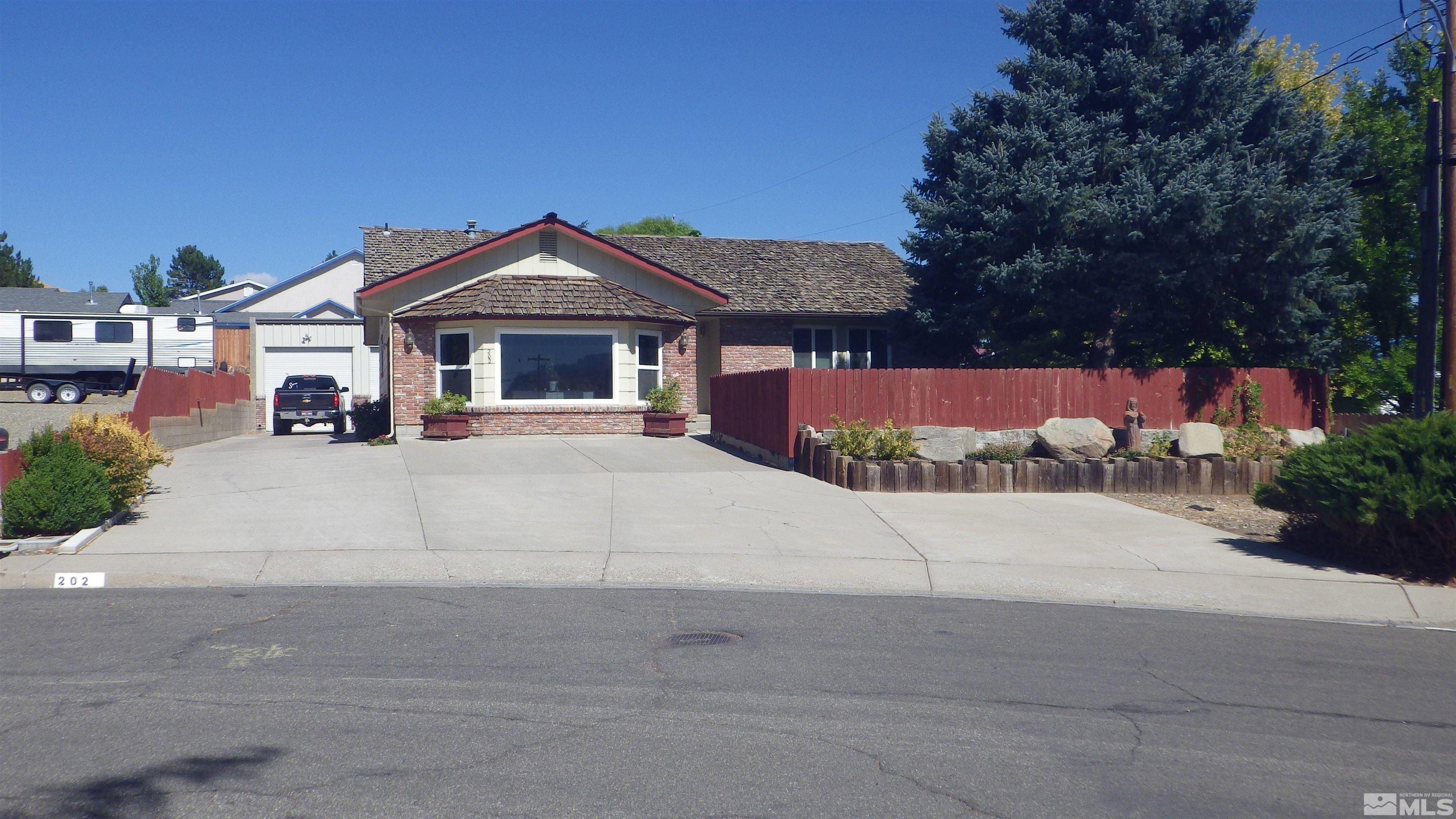 a view of a house with a yard and large tree