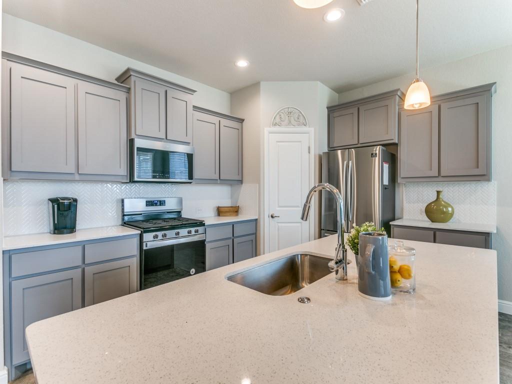 a kitchen with refrigerator a sink and a stove