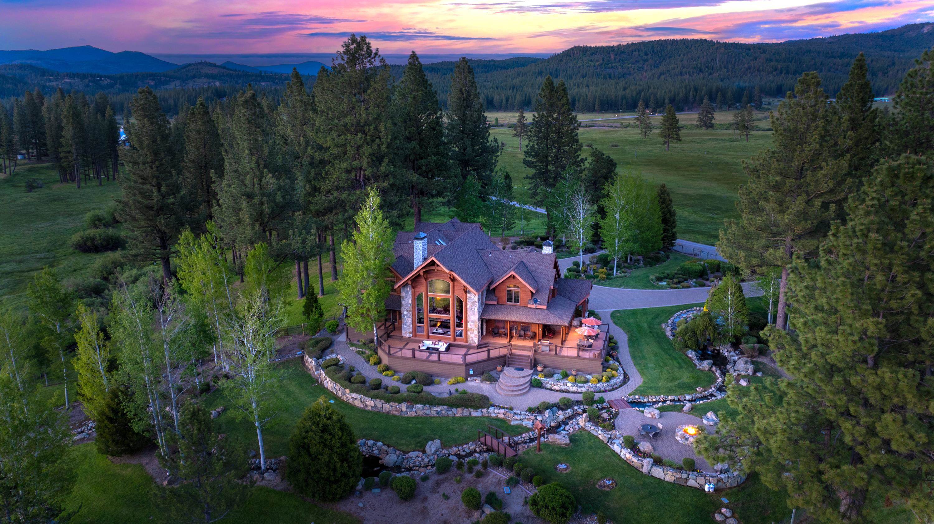 a view of a house with a yard and lake view