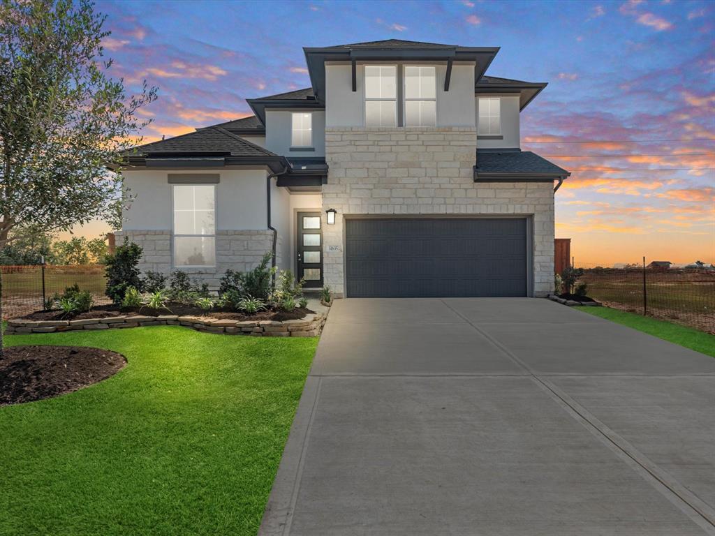 a front view of a house with a yard and garage