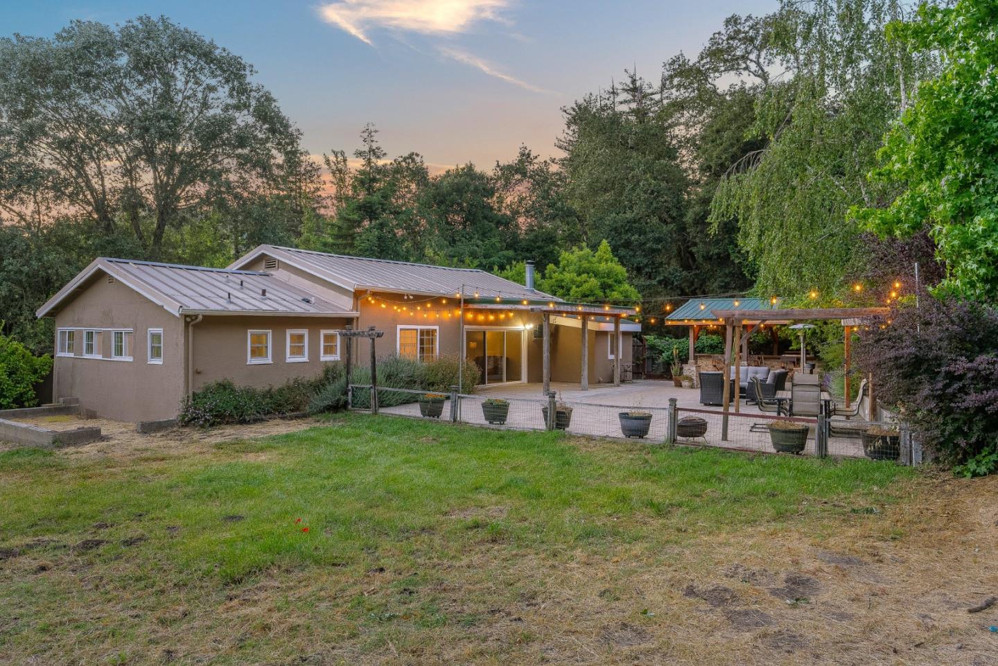 a view of a house with a big yard and large trees