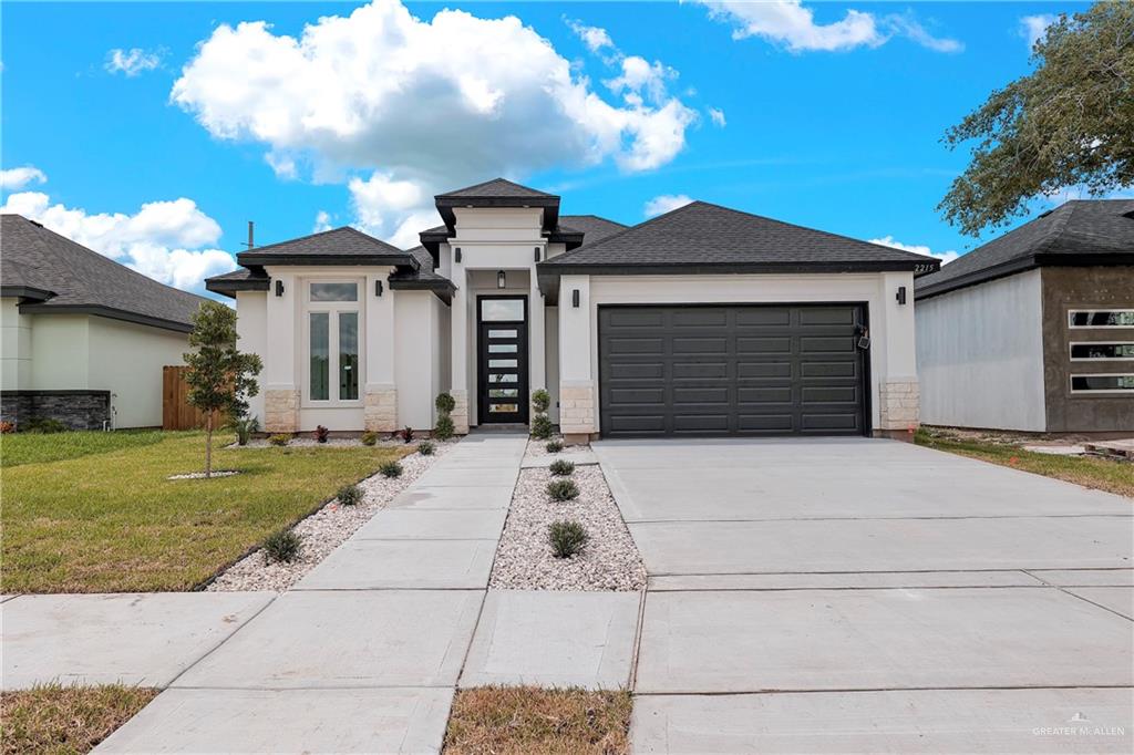 Prairie-style house featuring a front lawn and a garage