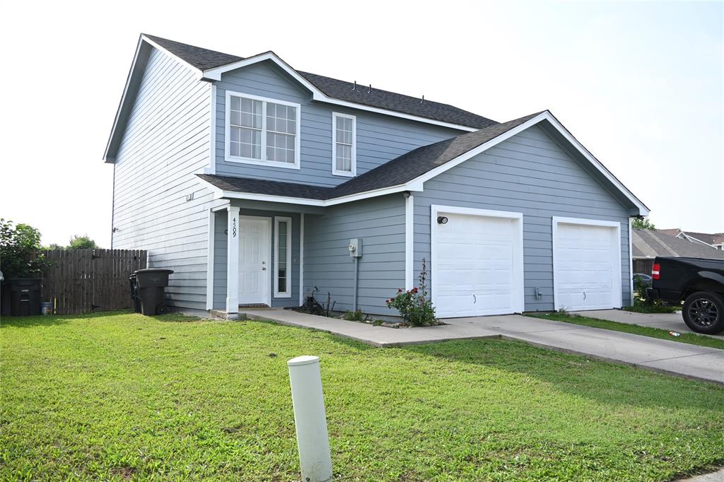 a front view of house with yard and garage