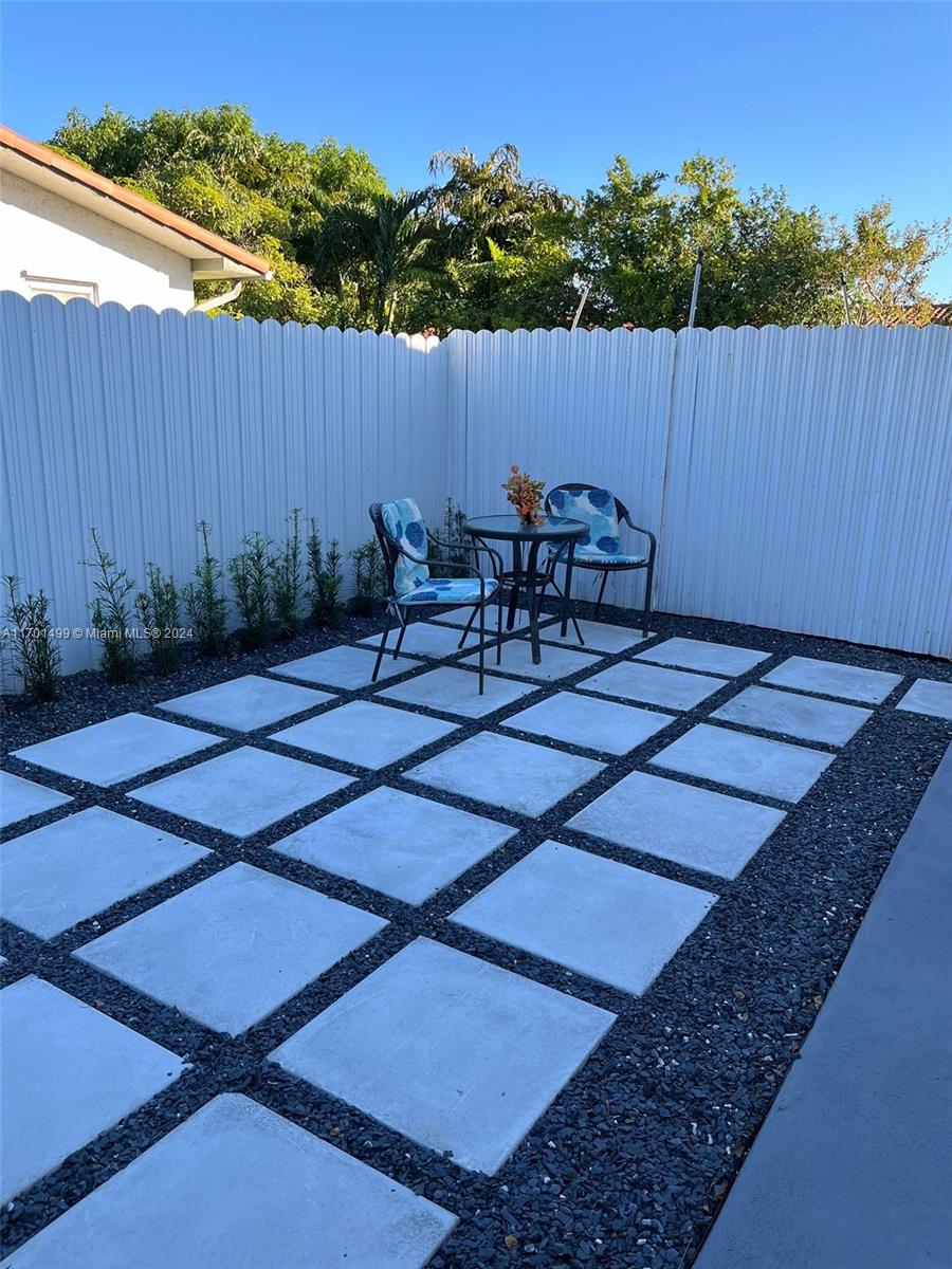 a backyard of a house with table and chairs