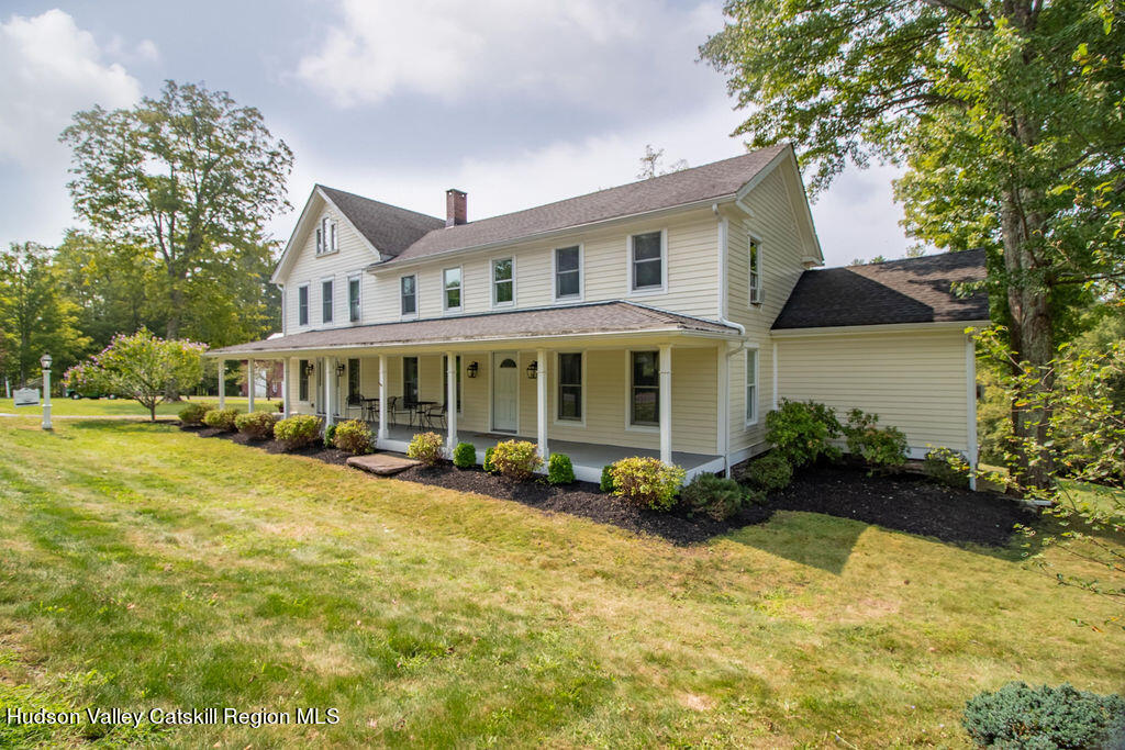 a front view of a house with a yard and potted plants