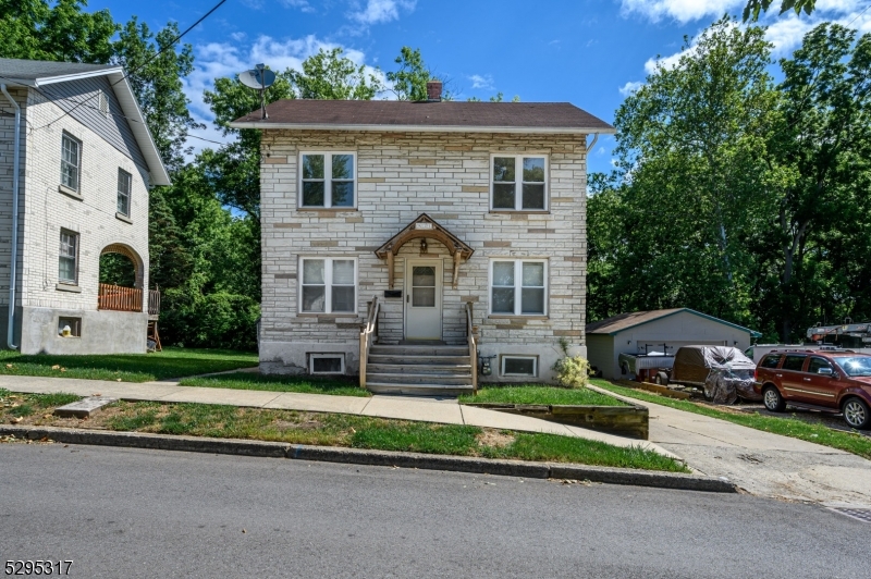 a front view of a house with a garden