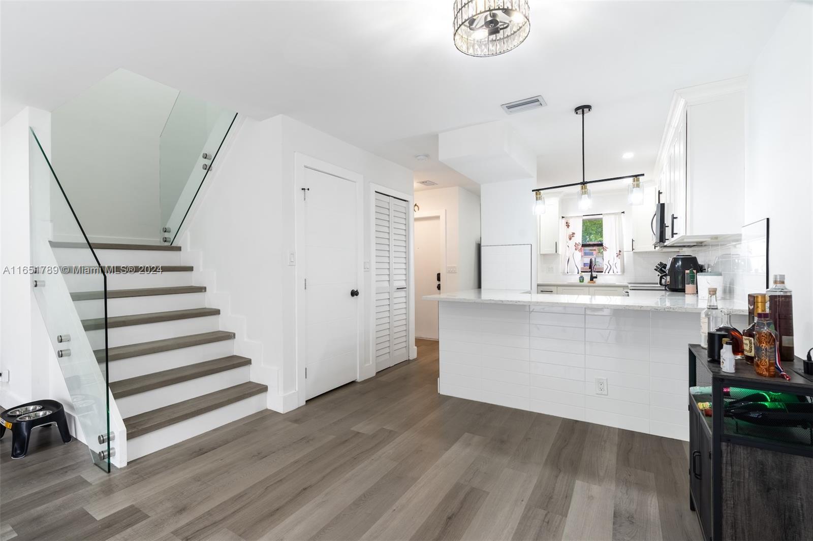 a view of kitchen with wooden floor and electronic appliances