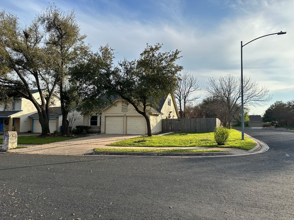 a front view of a house with a yard and trees