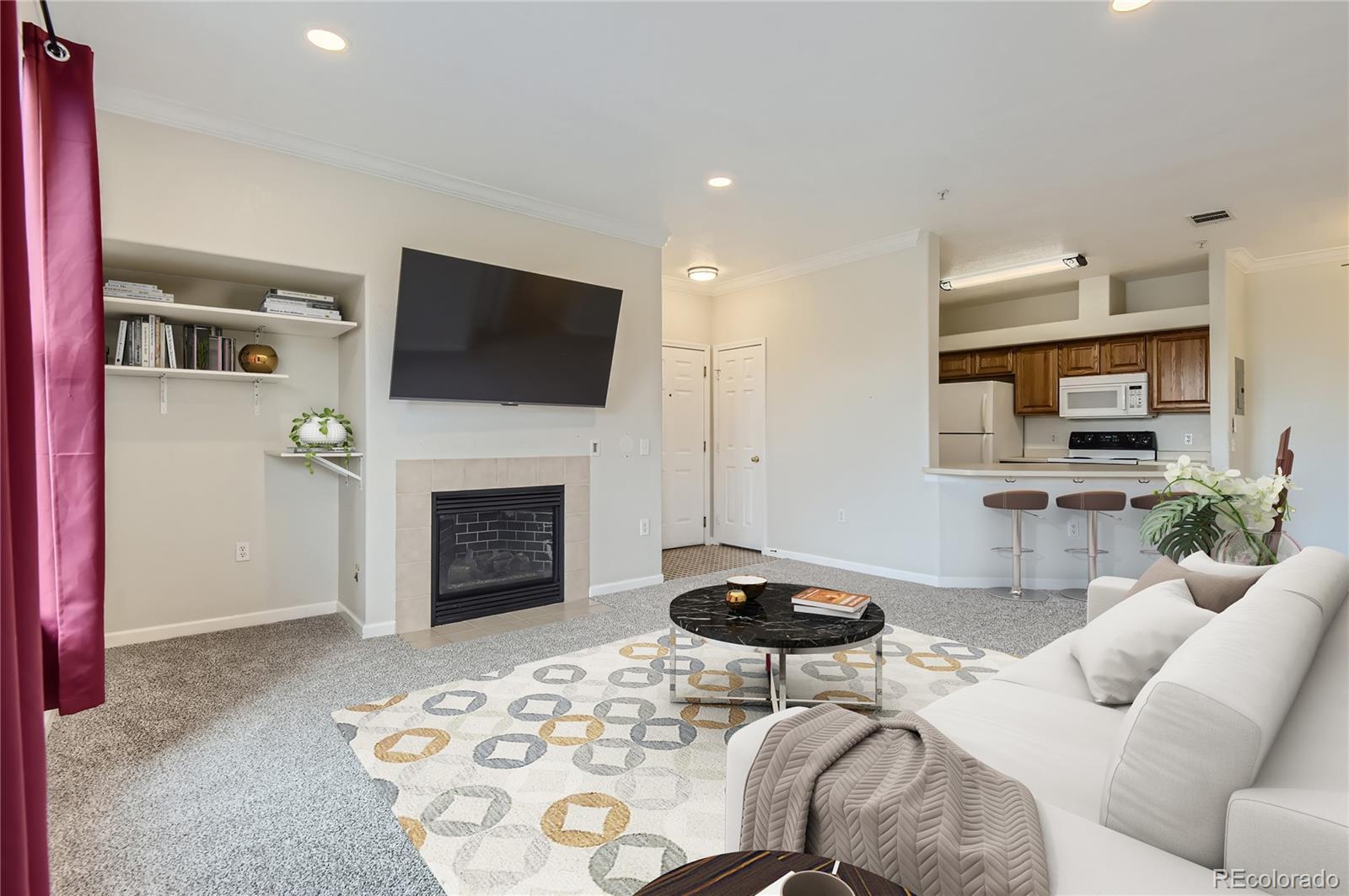 a living room with furniture a flat screen tv and a fireplace