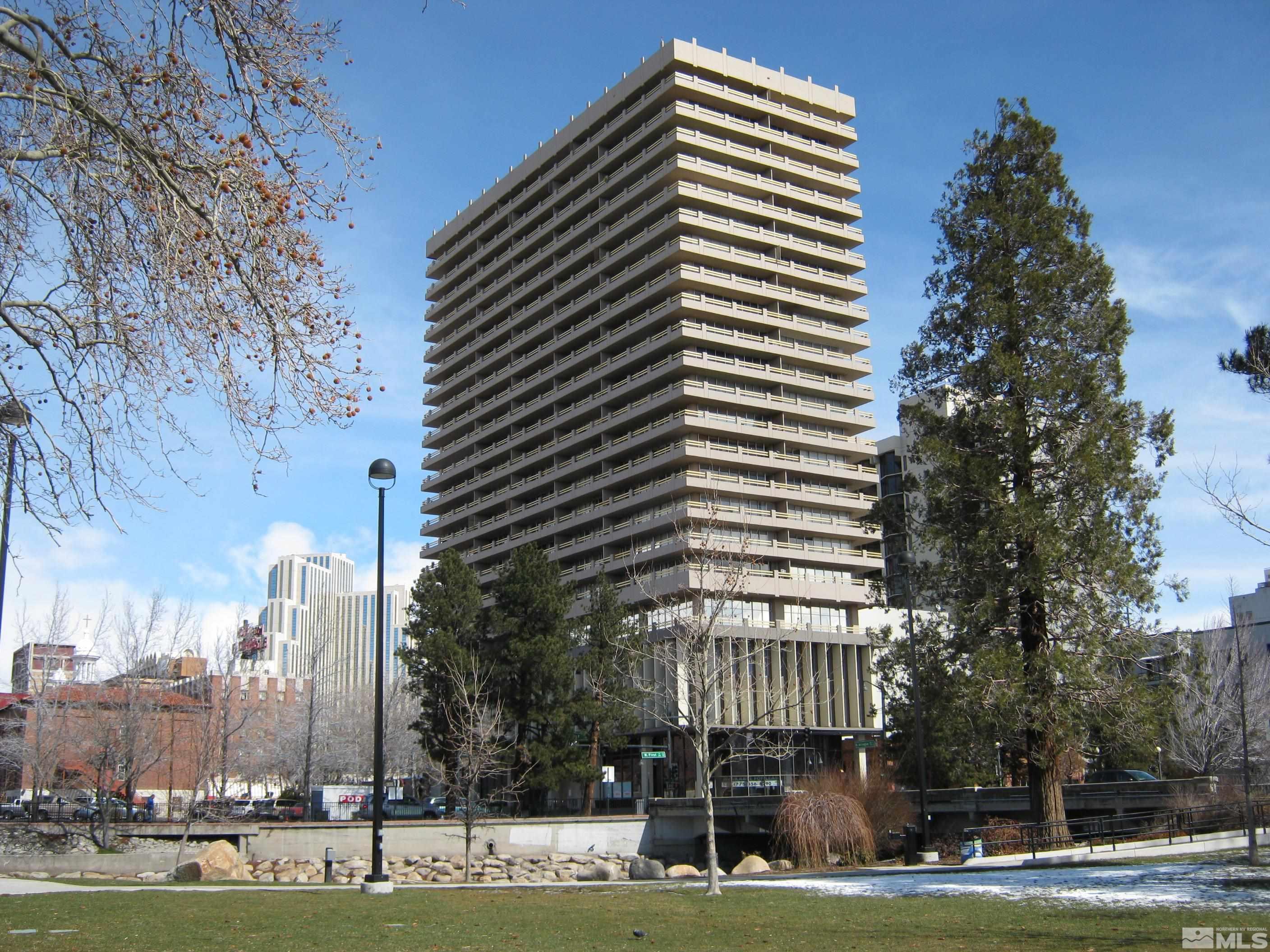 a front view of a building with streets and trees