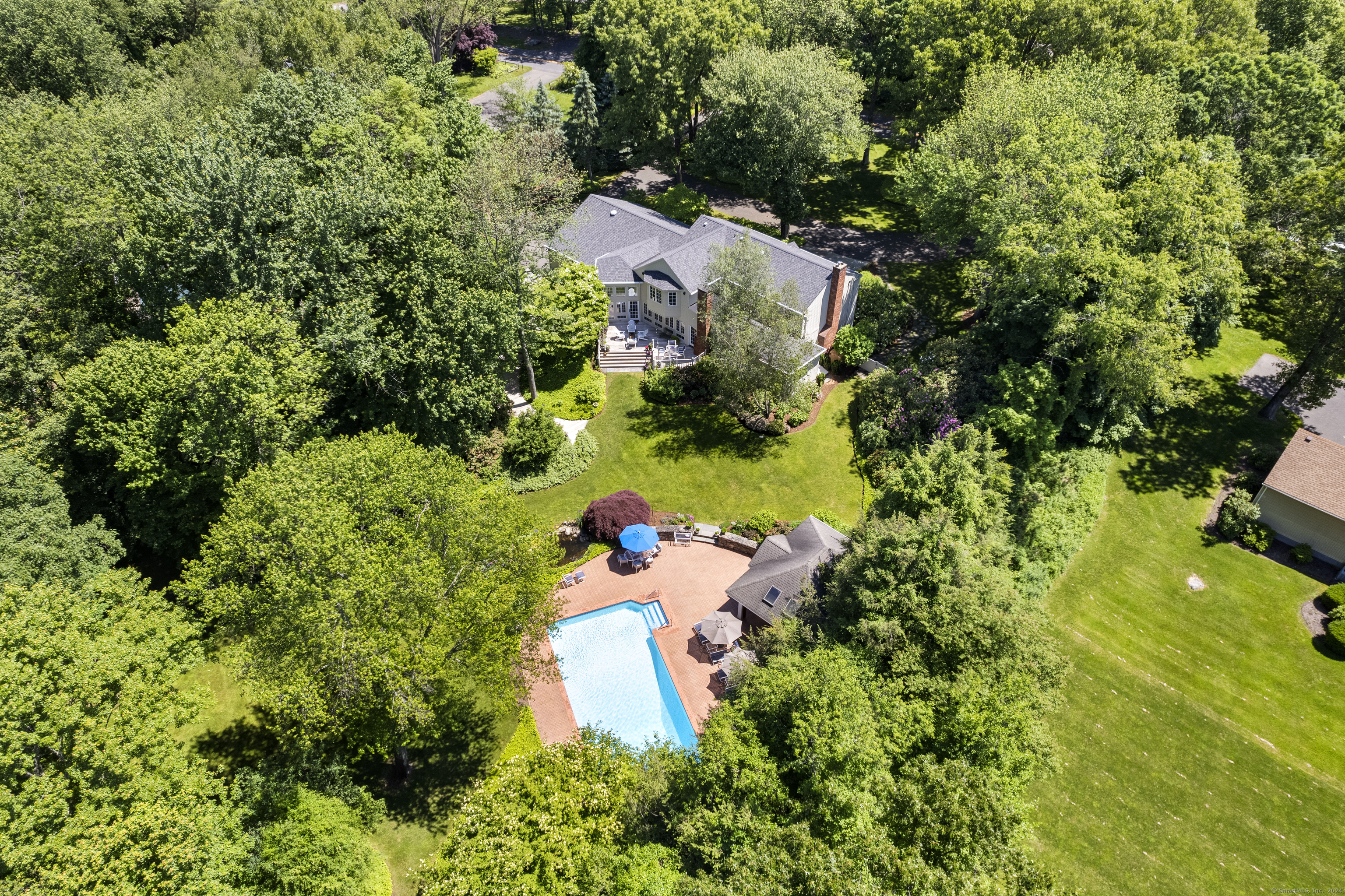 an aerial view of a house with a yard and large trees