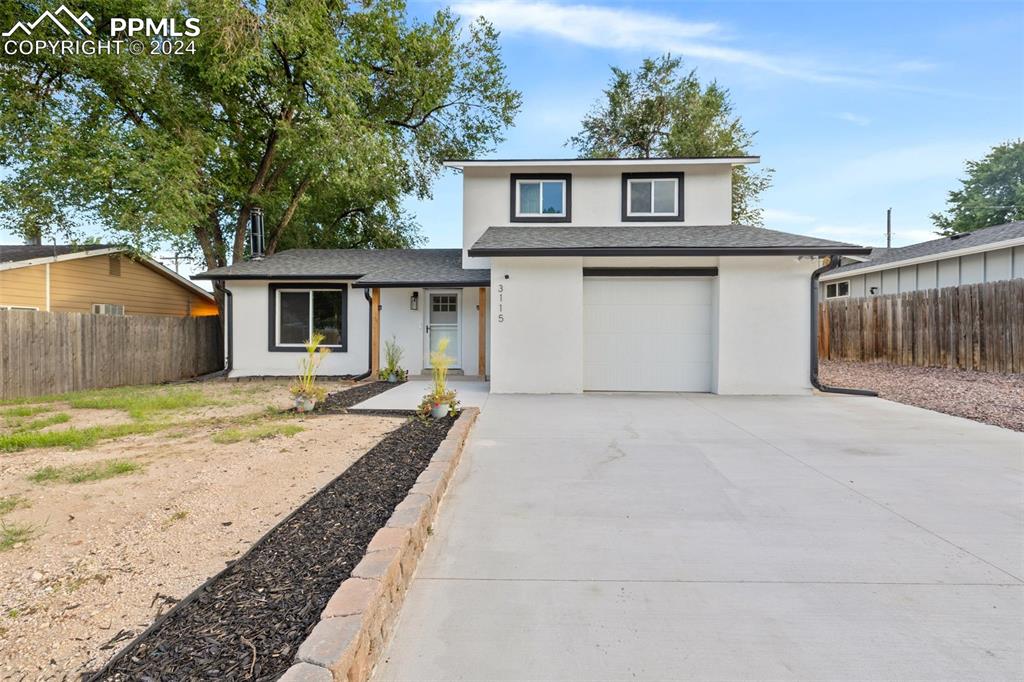 a view of a house with backyard and a tree