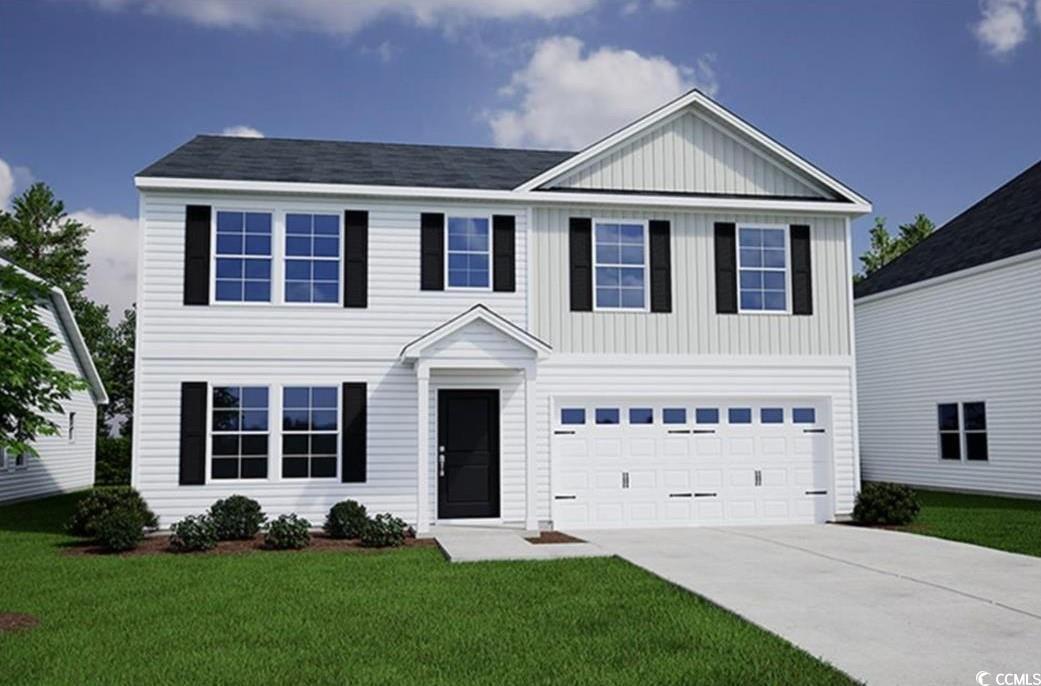 View of front of house with a front lawn and a gar