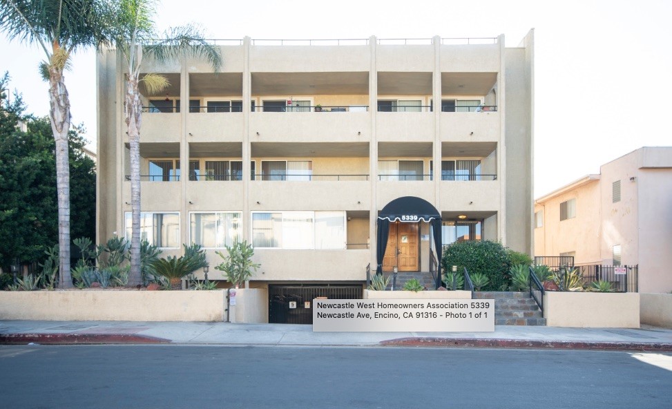 a front view of a building with a garden and entryway