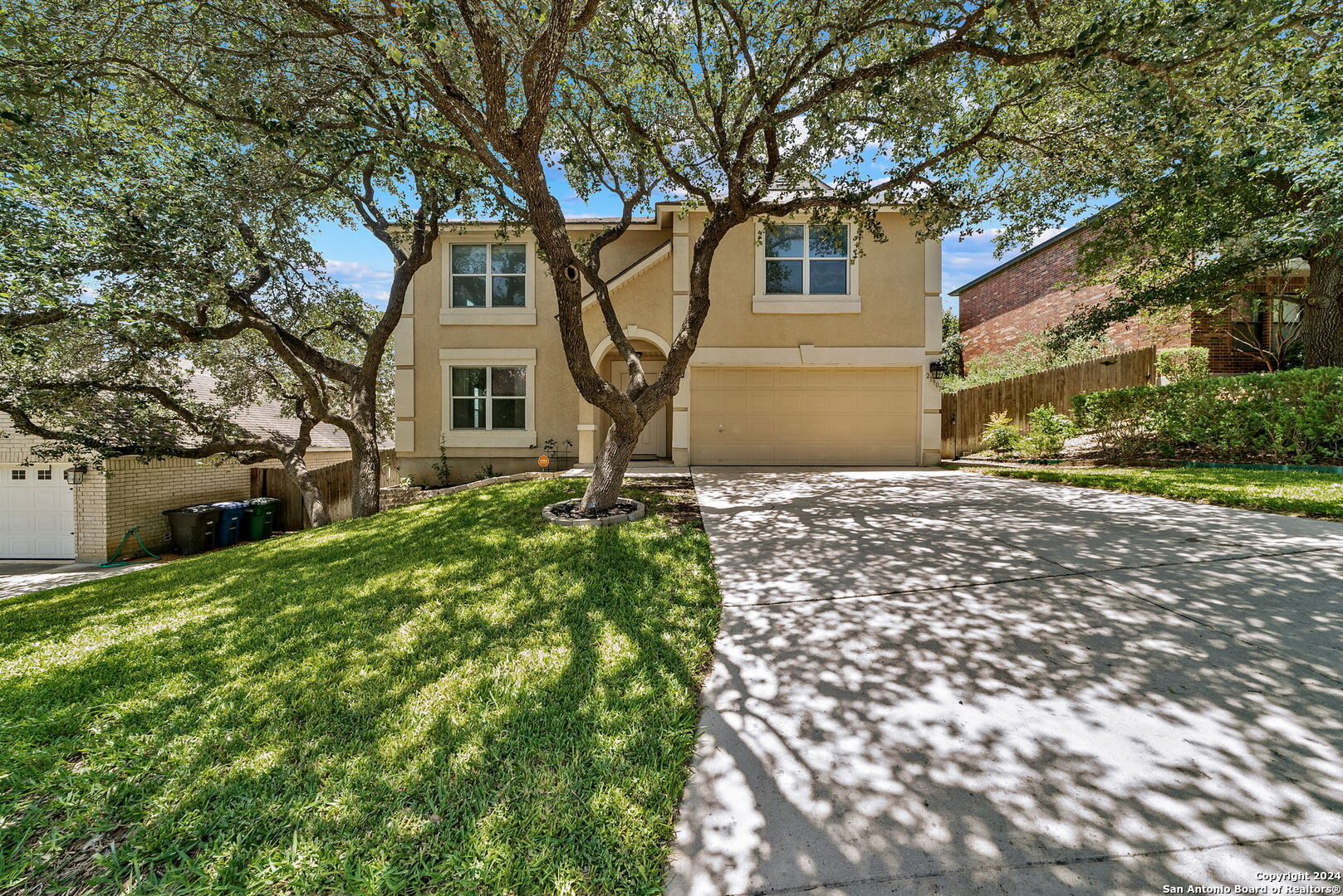 a front view of a house with a yard and trees