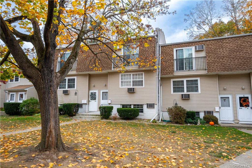 a front view of a house with a yard and trees