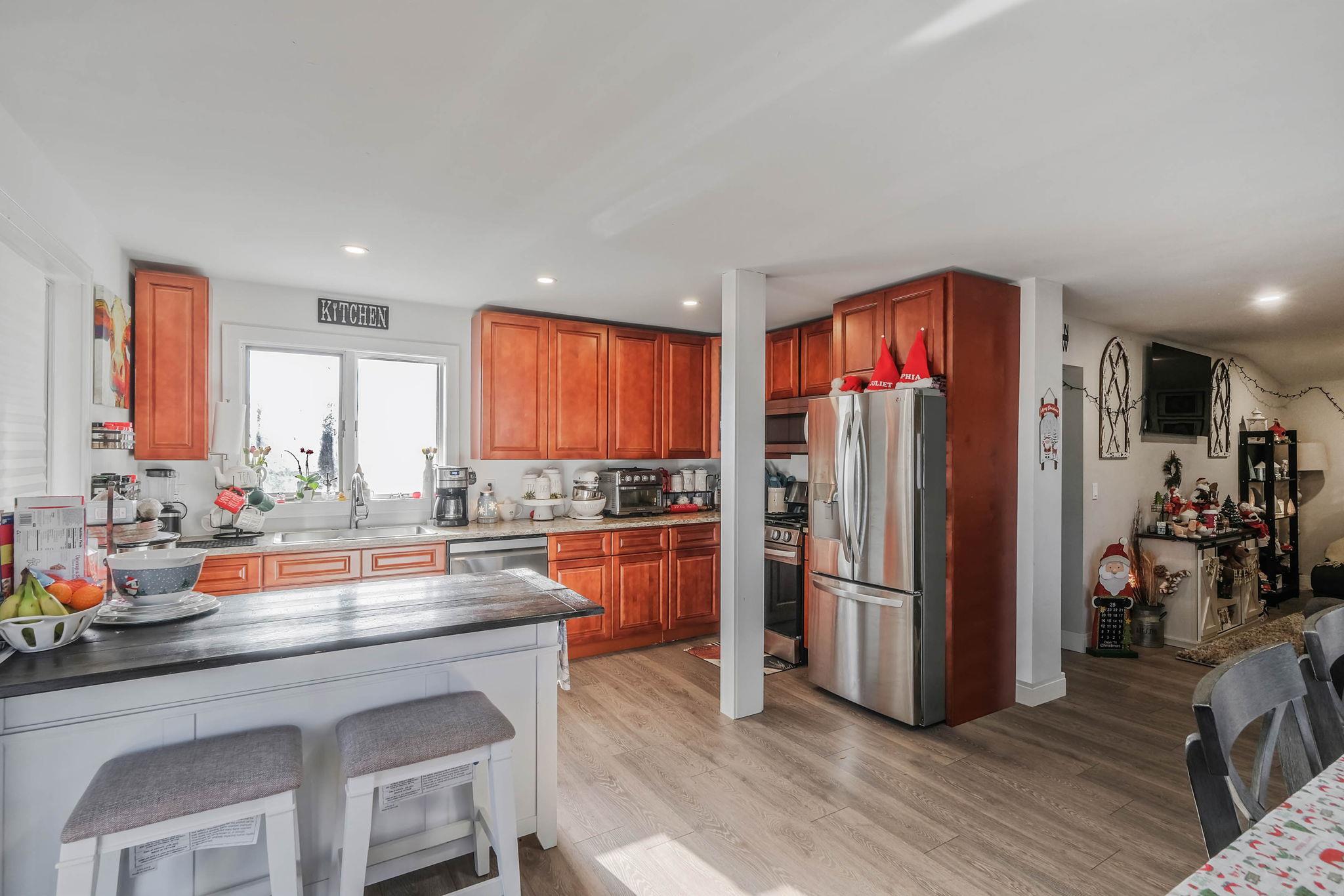 Kitchen featuring a kitchen breakfast bar, sink, light wood-type flooring, and stainless steel appliances