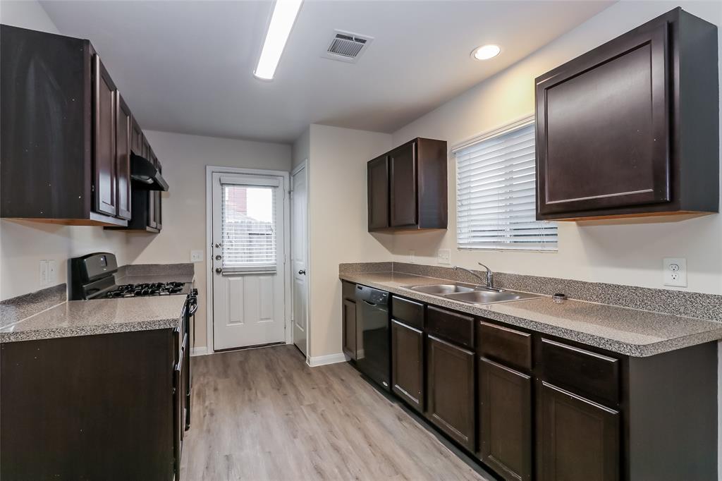 a kitchen with a sink stove top oven and refrigerator