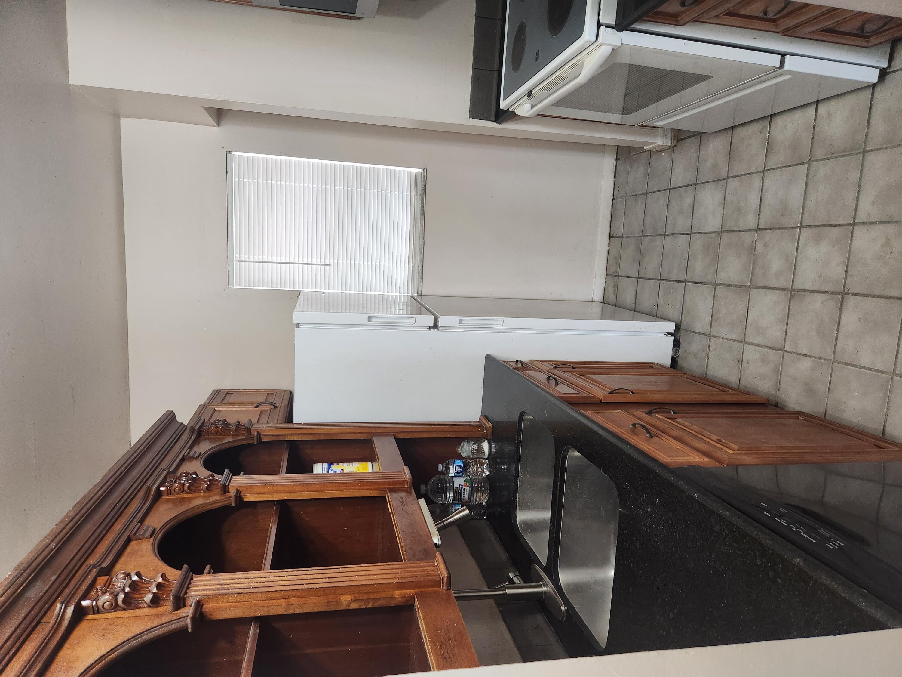 a kitchen with a sink a refrigerator and cabinets