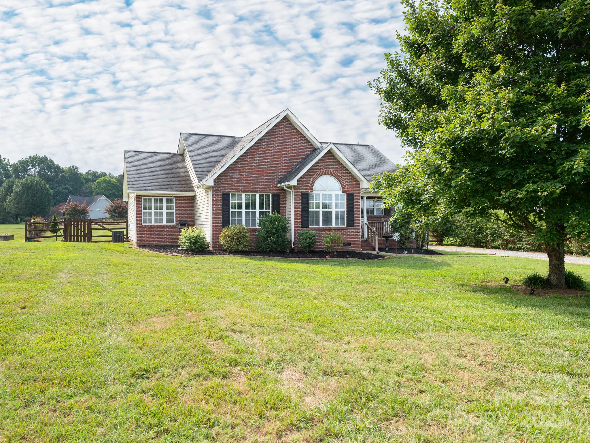 a front view of a house with a yard and trees