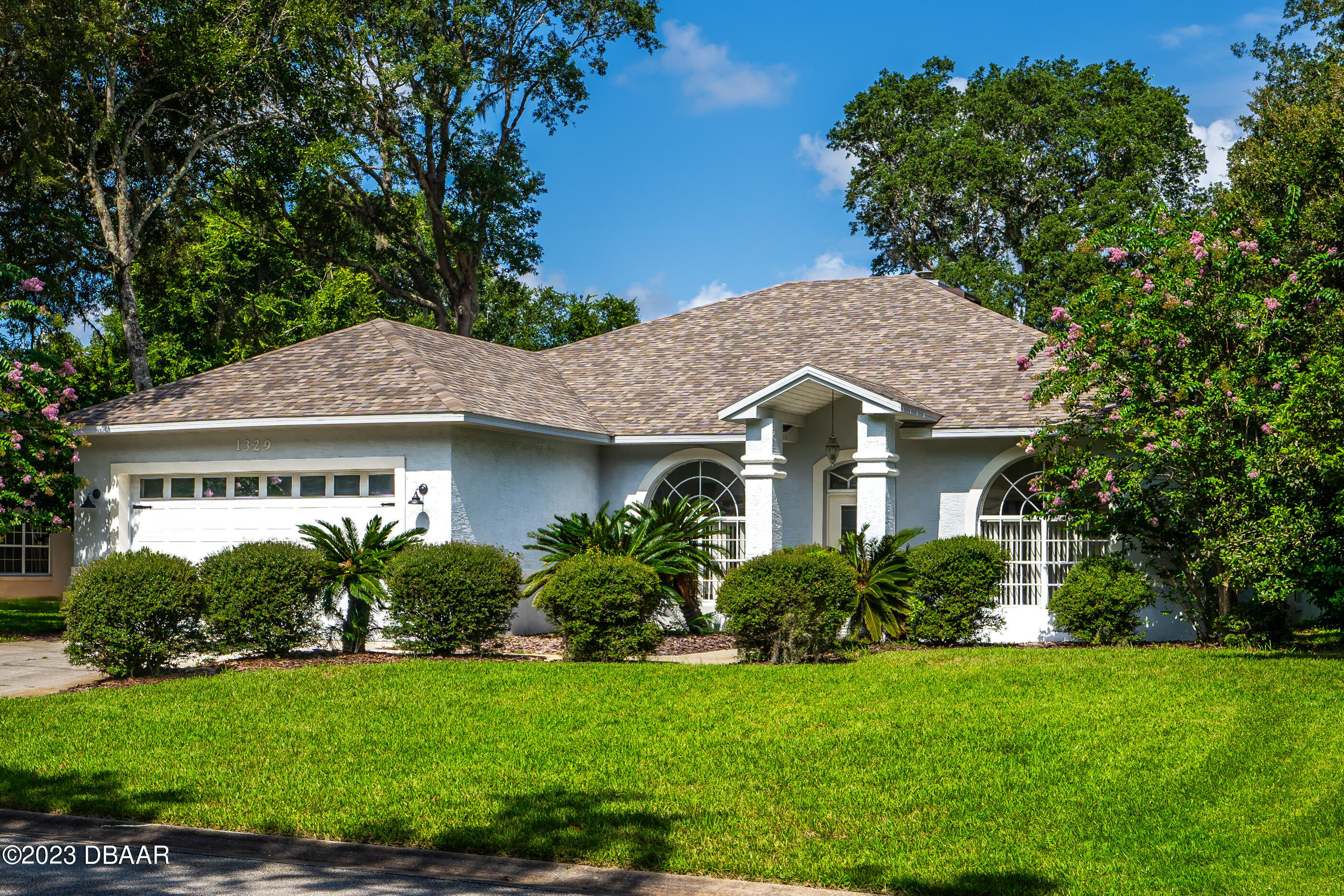 a front view of a house with a garden