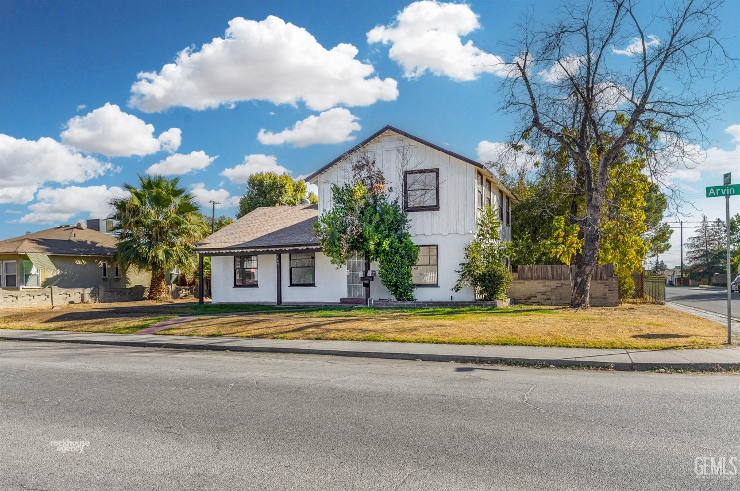 a front view of a house with a yard and trees