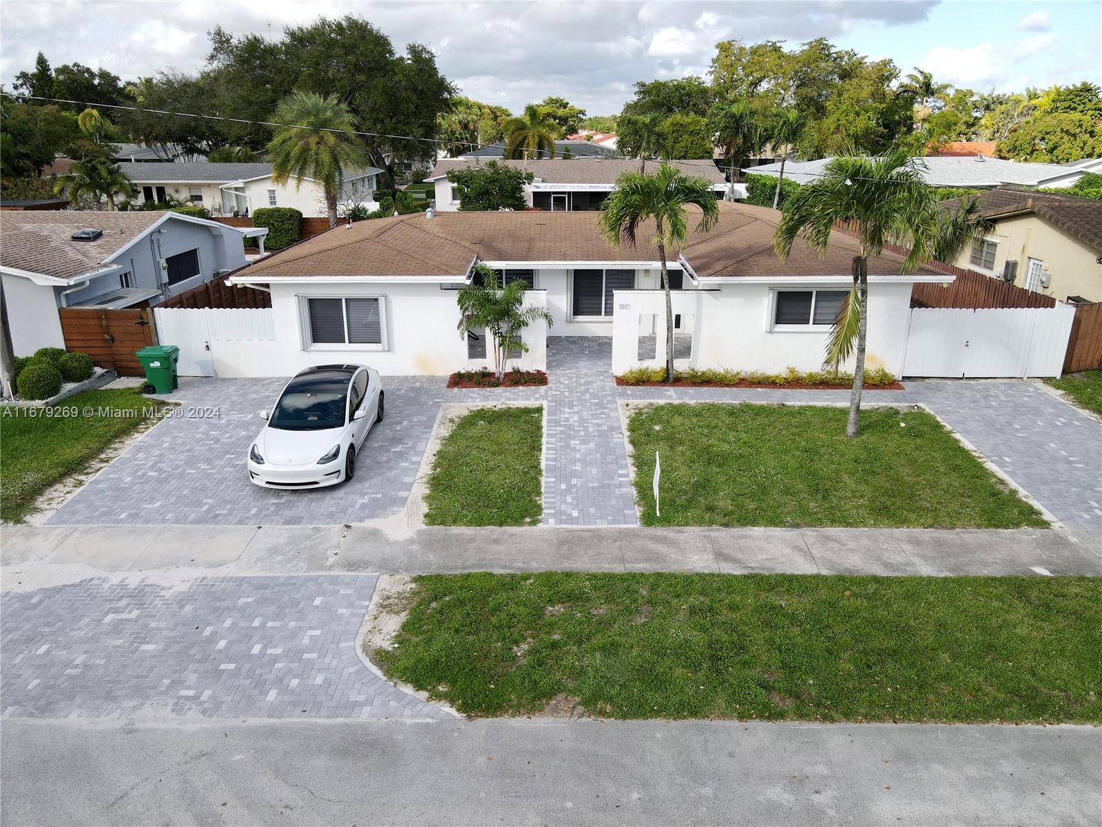 an aerial view of residential houses with outdoor space and parking