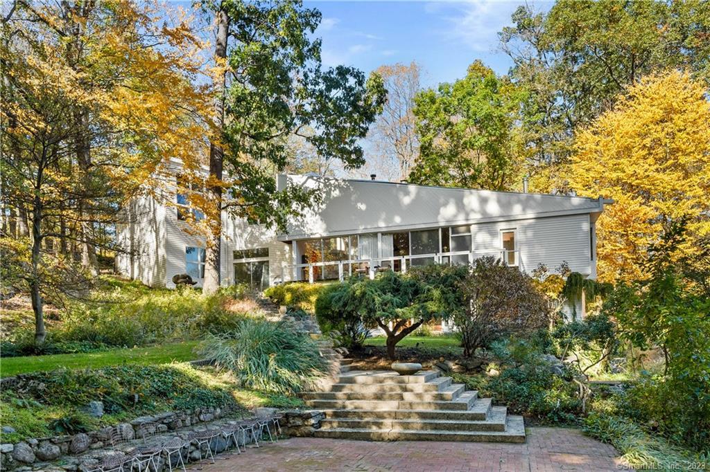 a front view of a house with a yard and tree s