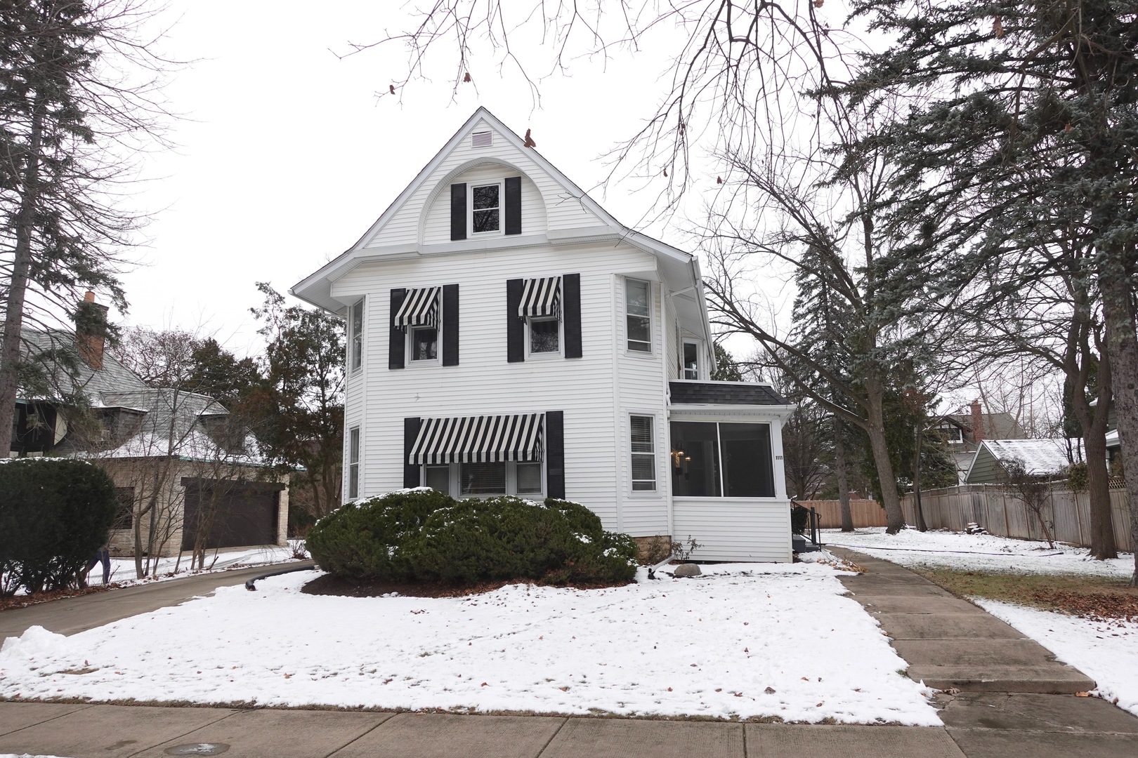 a front view of a house with a yard covered in snow