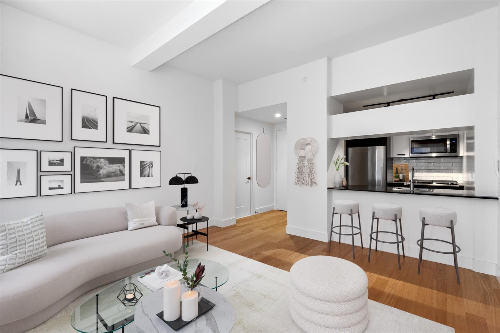 a living room with furniture a flat screen tv and kitchen view