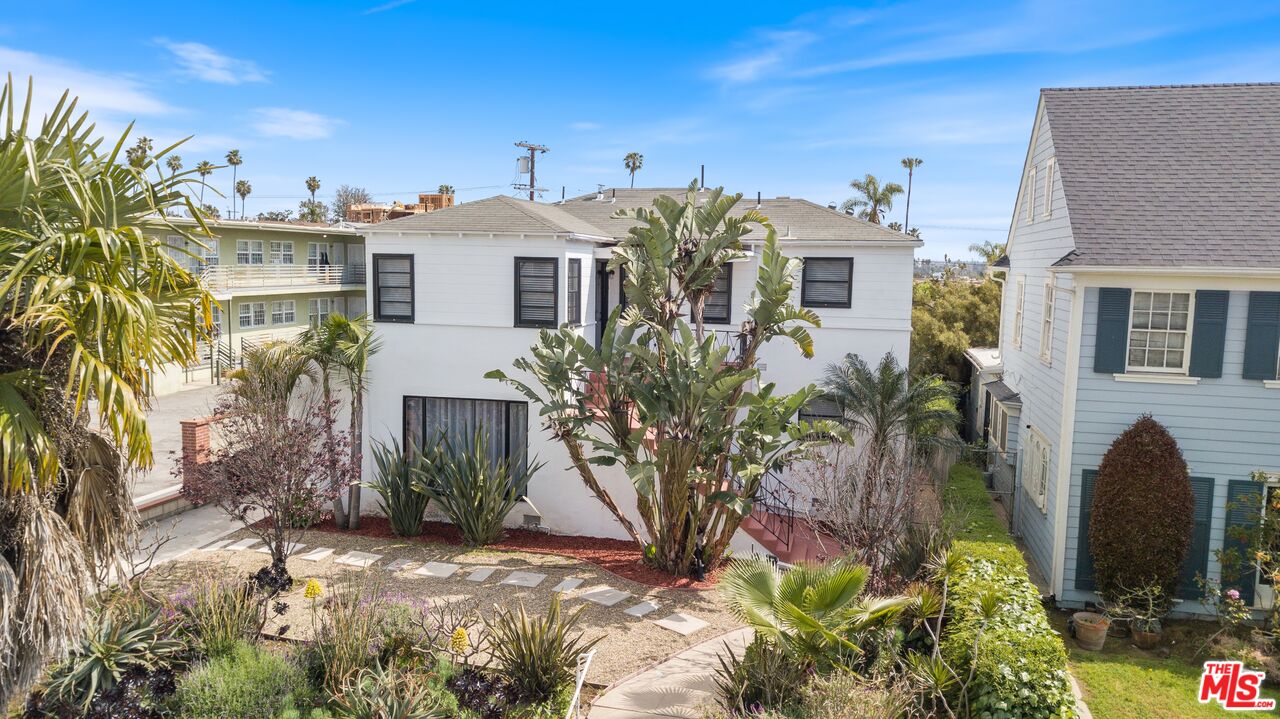 a view of a house with a yard and potted plants