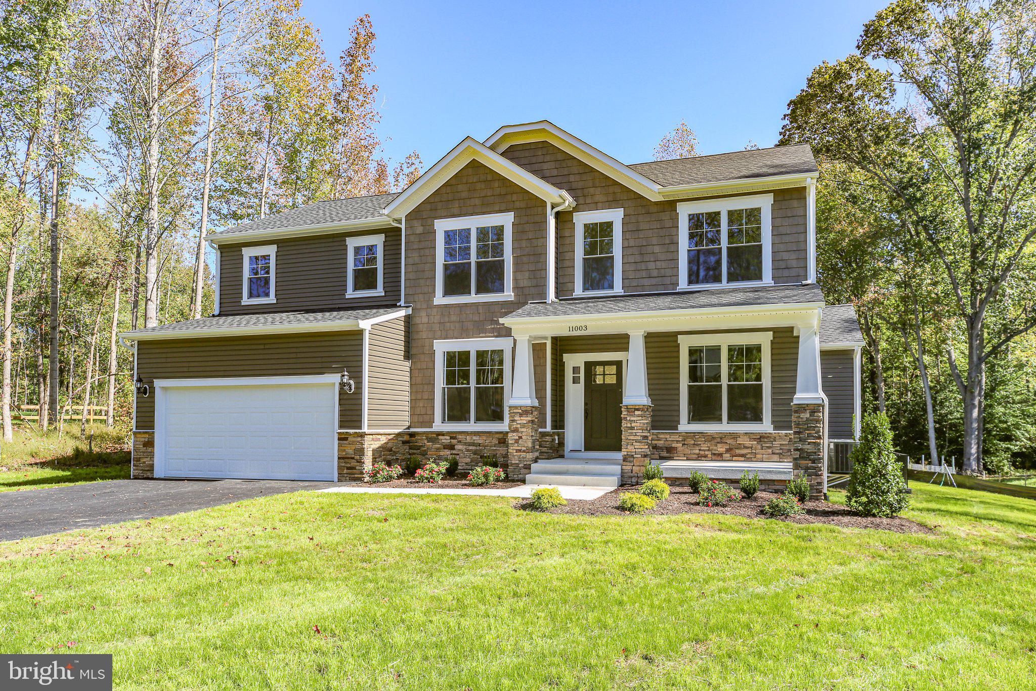 a front view of a house with a yard outdoor seating and garage