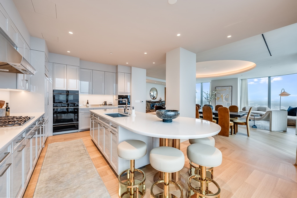 a large kitchen with cabinets a sink a counter and chairs