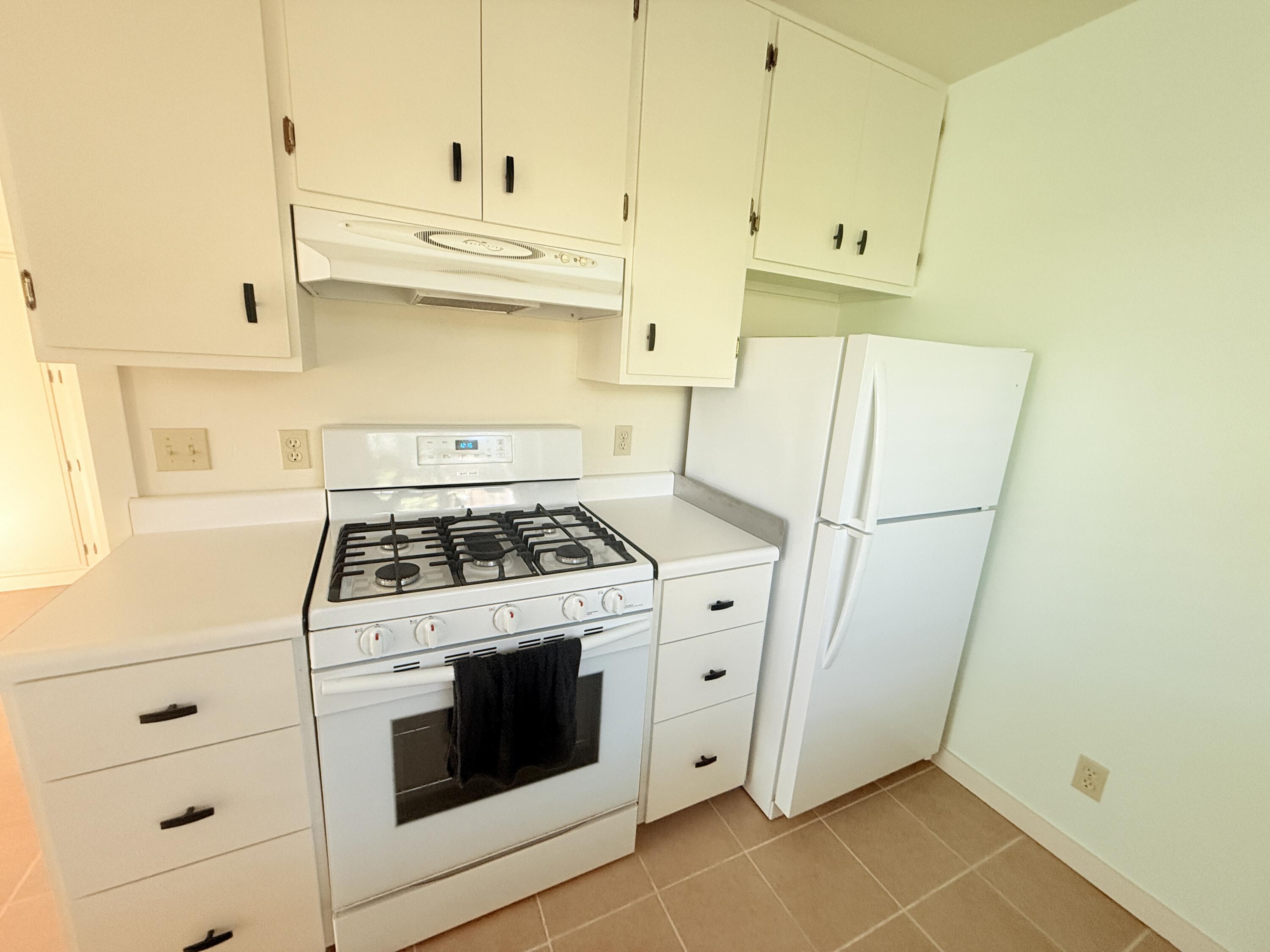 a kitchen with white cabinets and white appliances