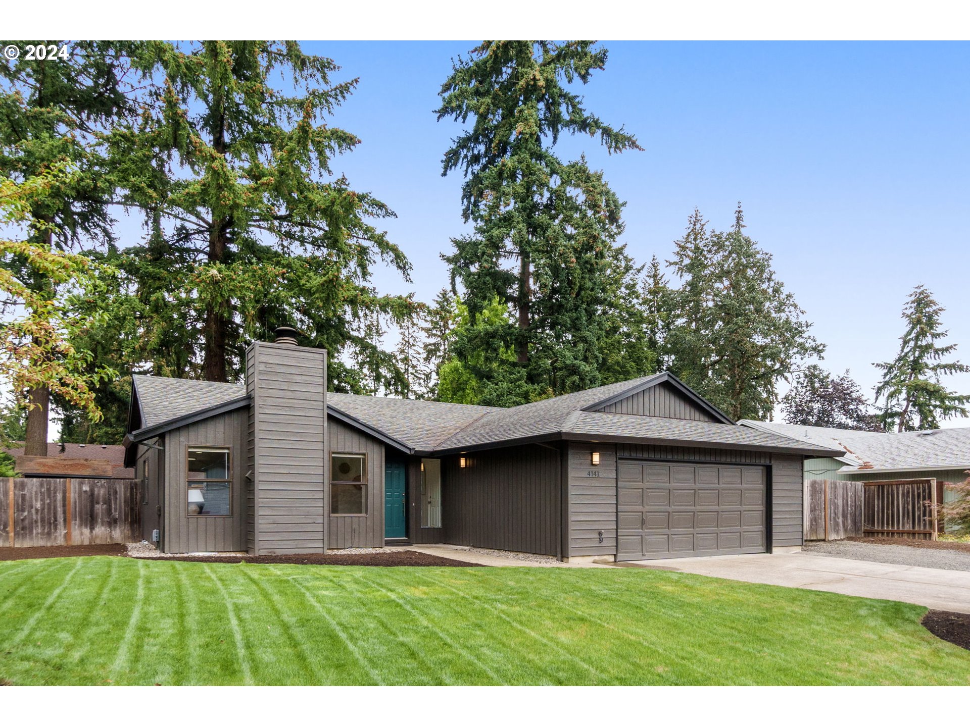 a front view of a house with a yard and trees