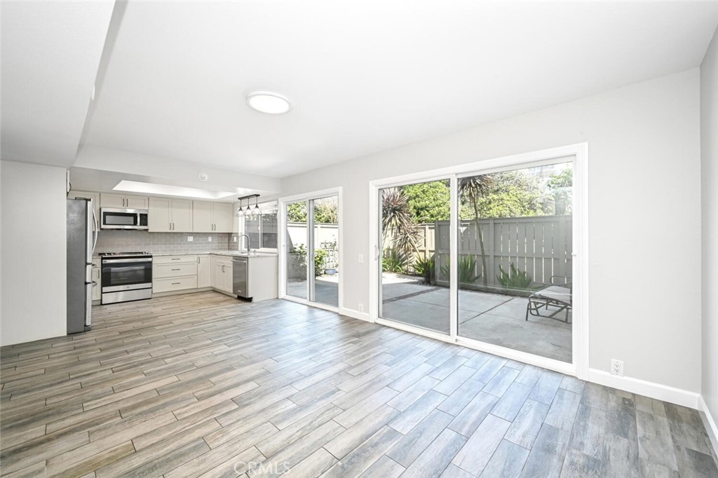 a view of empty room with wooden floor and floor to ceiling window