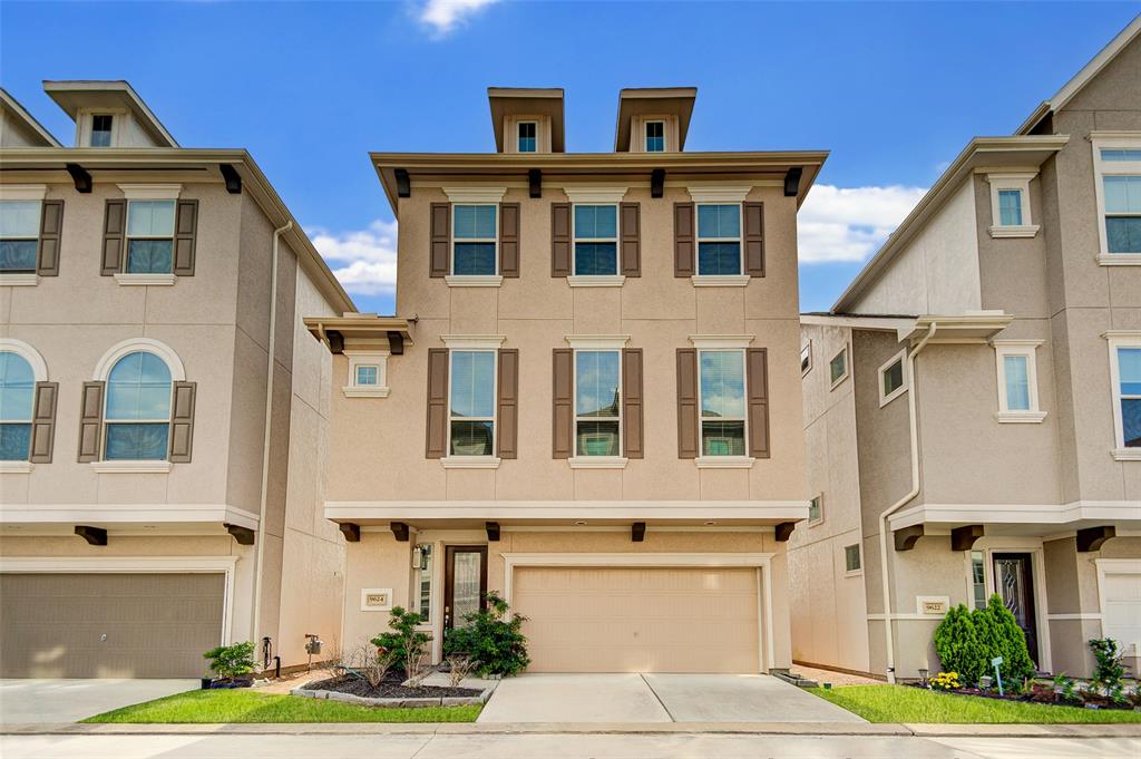 a front view of a house with yard and parking