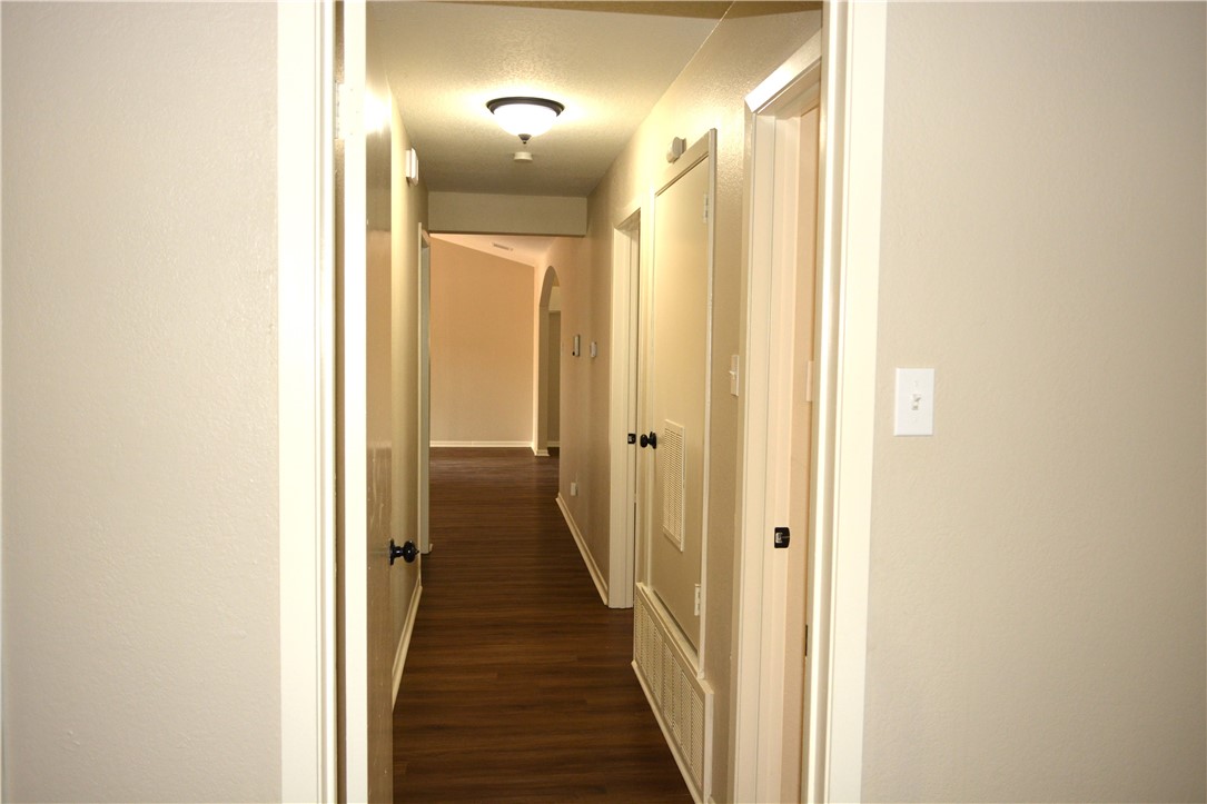 a view of a hallway with a door and wooden floor