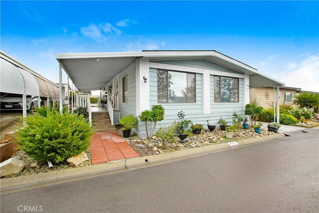 a front view of a house with a yard and potted plants