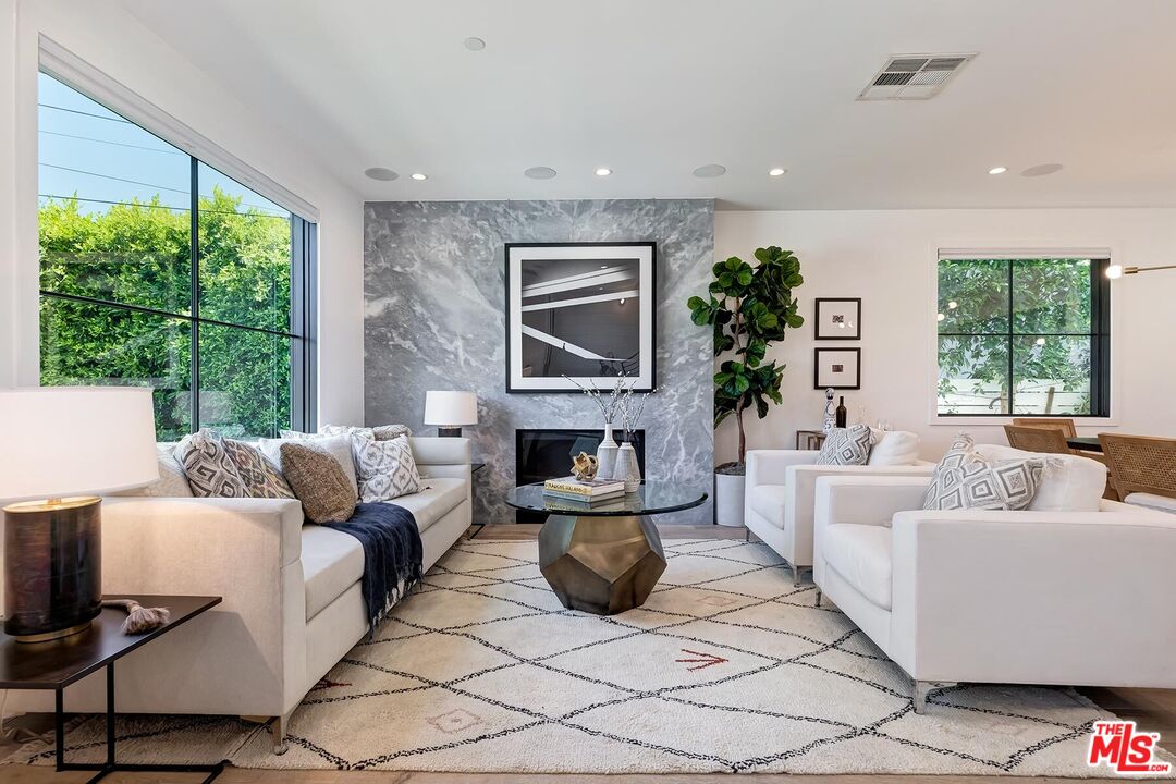 a living room with fireplace furniture and a large window