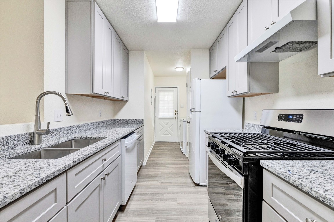 a kitchen with stainless steel appliances granite countertop a sink stove and cabinets