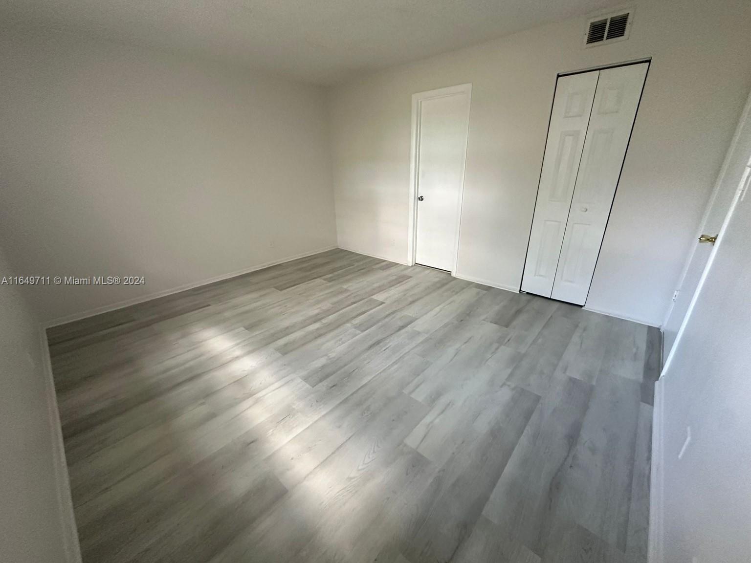 a view of an empty room and wooden floor