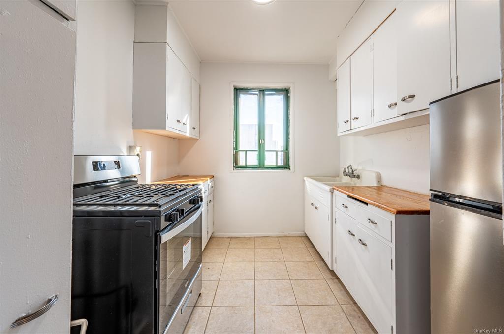 a kitchen with granite countertop a sink stove and refrigerator