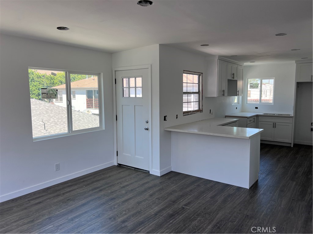 a kitchen with granite countertop wooden floors and wide window