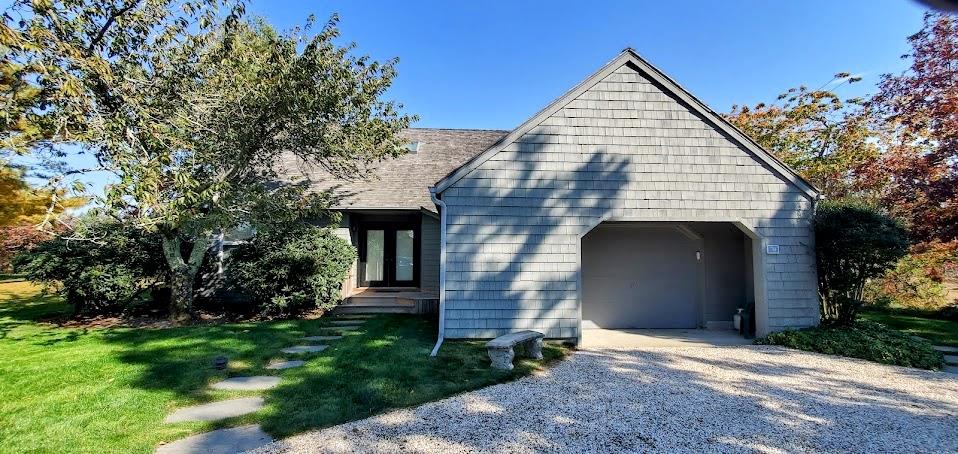 View of side of property with a lawn, a garage.