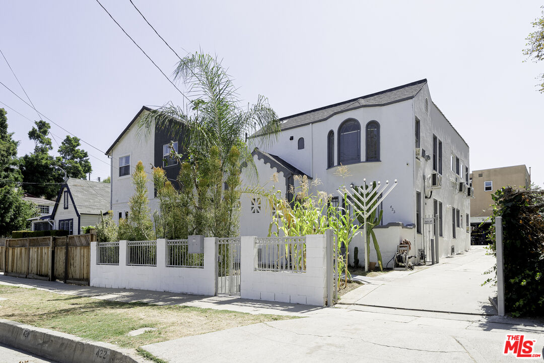 a view of a house with a small yard and potted plants